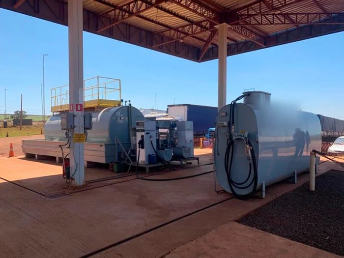 Posto de abastecimento empresarial com tanques, bombas e medidores em operação